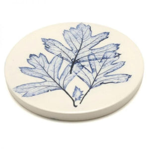 Handmade coaster made from clay with a leaf imprint in blue